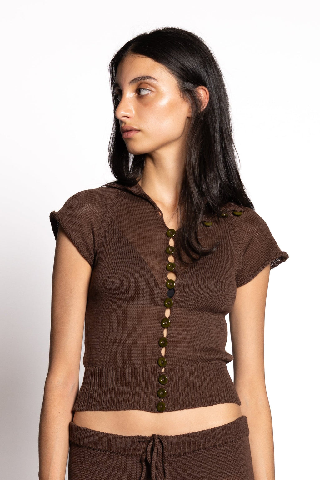 Woman wearing a brown outfit with a top and pants on a white background