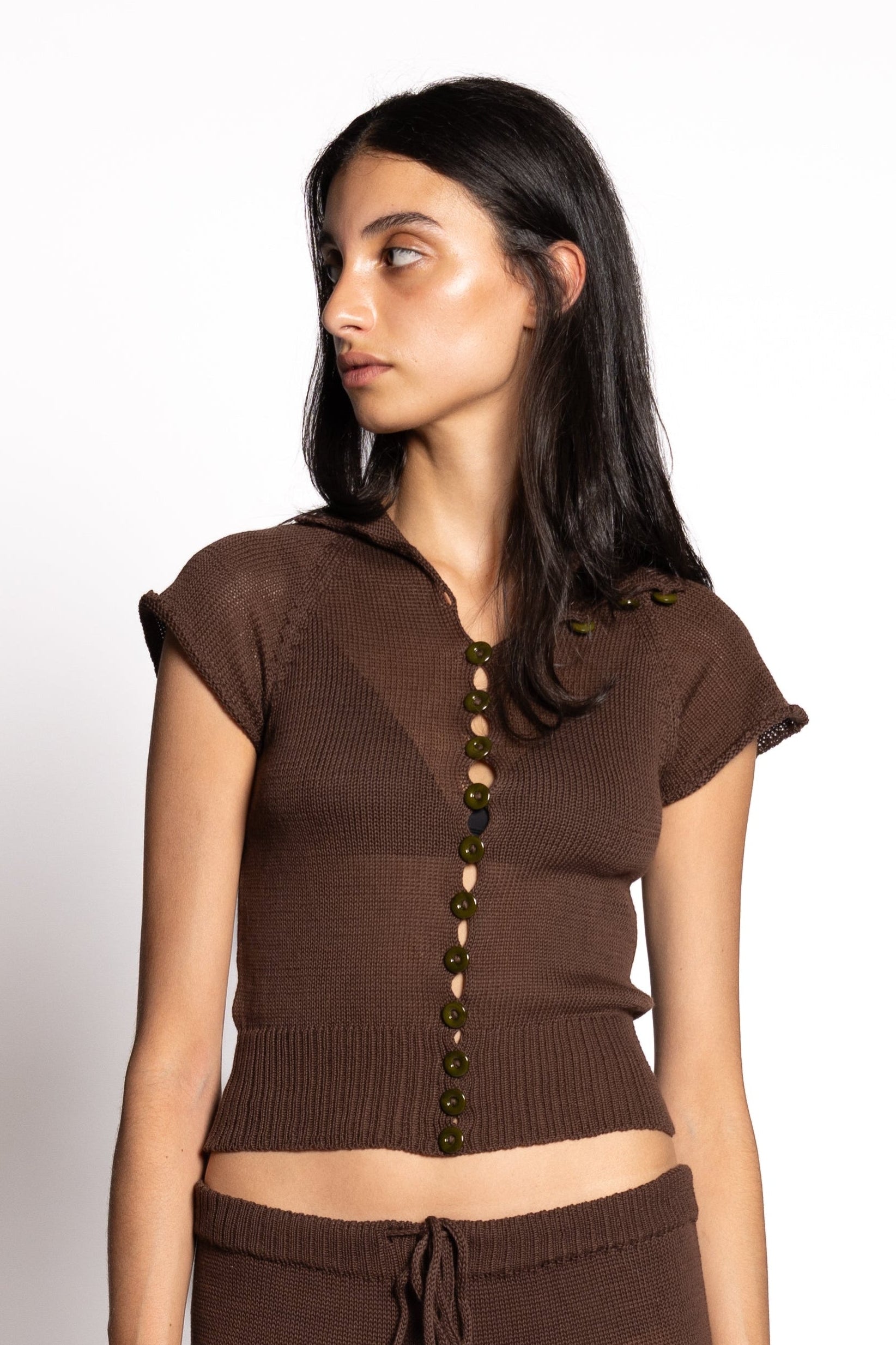 Woman wearing a brown outfit with a top and pants on a white background
