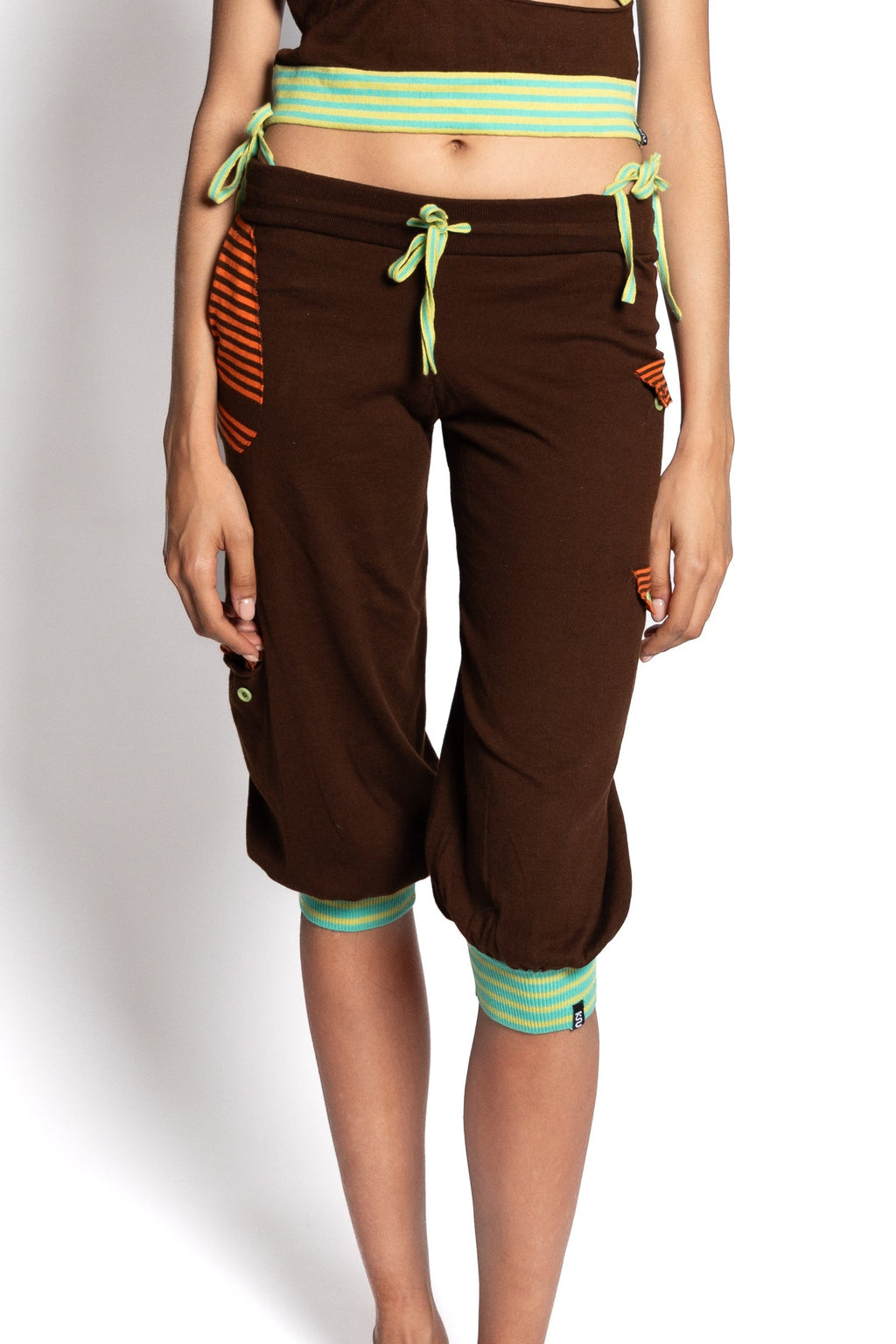 Woman wearing a colorful top and brown capri pants on a white background